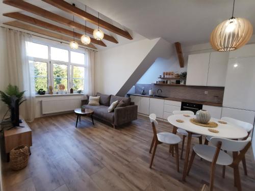 a living room with a table and a couch at Harmony Apartment in Ostróda