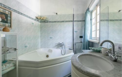 ein weißes Badezimmer mit einer Badewanne und einem Waschbecken in der Unterkunft Awesome Home In Massarosa -lu- With Wifi in Mommio