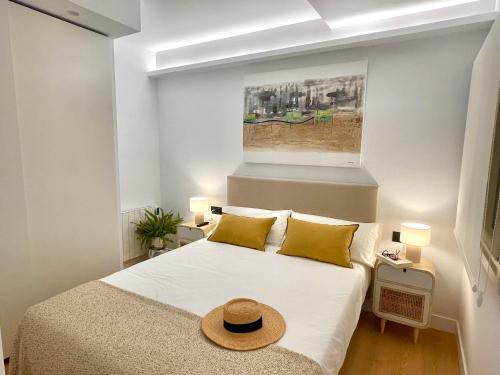 1 dormitorio con 1 cama con sombrero en APARTAMENTO MENTURA Centro de San Sebastian Parking FREE, en San Sebastián