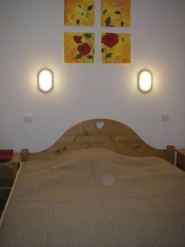 - une chambre avec un lit et deux lumières sur le mur dans l'établissement Appartement lumineux à Orcières 1850, à Orcières