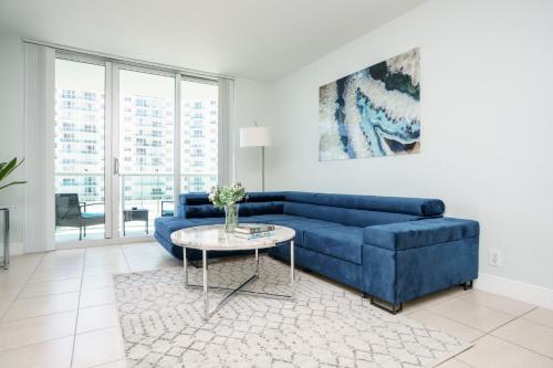 - un salon avec un canapé bleu et une table dans l'établissement Modern 1 BDR Oceanview with direct beach access!, à Hollywood