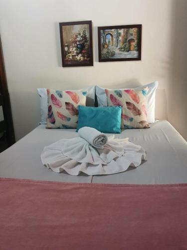 a white bed with pillows and a towel on it at Pousada Dois Rios in Barra do Garças
