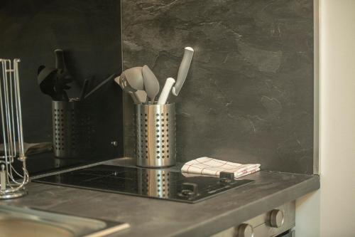 een aanrecht met keukengerei in een metalen container bij KASA FACTORY - Au calme - TV & WIFI in Saint-Quentin