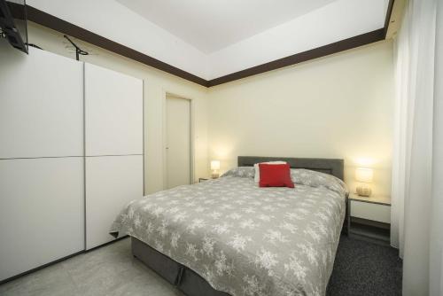 Un dormitorio con una cama con una almohada roja encima. en Hortensia, en Šibenik