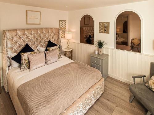 1 dormitorio con 1 cama grande y espejo grande en The Golden Crown en Tarbolton