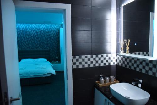 1 cama y baño con lavabo y aseo. en Vb apartmani, en Prijedor