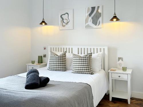 1 dormitorio con cama blanca y almohadas blancas y negras en The Yorkshire Hosts - The Tailor's Lounge en Ripon