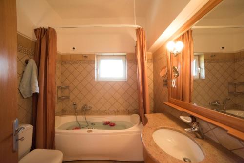 a bathroom with a tub and a toilet and a sink at Our Dreamhouses in Loutraki Heraion Sea Lake in Loutraki