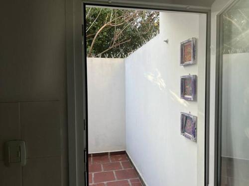 eine offene Tür zu einer weißen Wand mit Gemälden darauf in der Unterkunft depto Artigas in Tandil