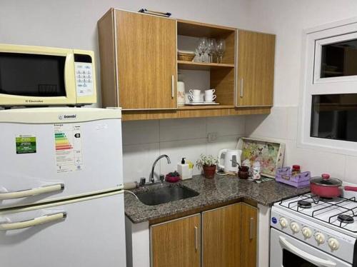 eine Küche mit einem weißen Kühlschrank und einer Spüle in der Unterkunft depto Artigas in Tandil