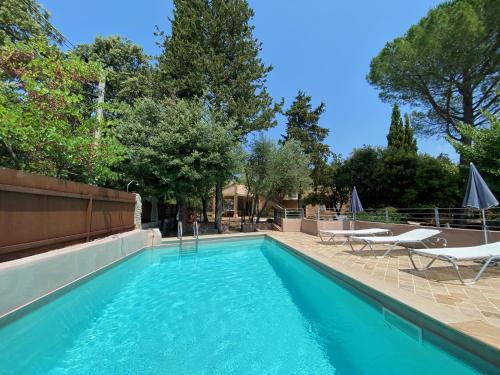 une piscine avec deux chaises longues et une piscine dans l'établissement Campagne du XVII au luxe simple, à Lorgues