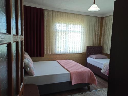 a small bedroom with two beds and a window at Local Home in Çağlayan