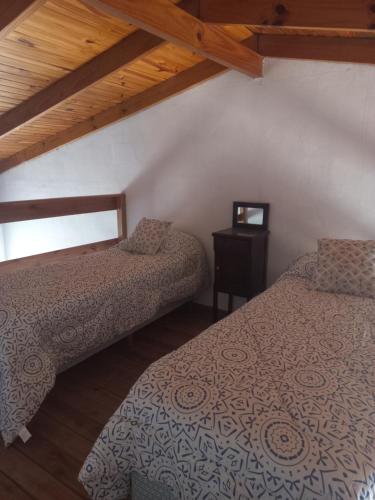 a bedroom with two beds and a table with a window at La Yuma en Villars in Villars