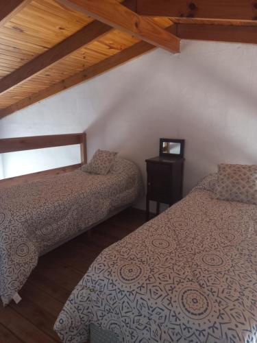 a bedroom with two beds and a table with a window at La Yuma en Villars in Villars