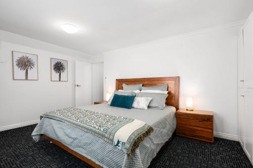 a bedroom with a large bed and a night stand at Amelia Terrace - House in Brisbane City Central in Brisbane
