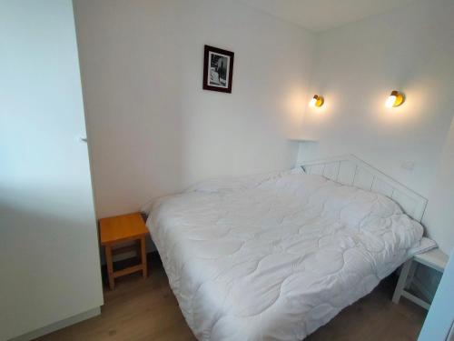 - une chambre avec un lit blanc et deux lumières sur le mur dans l'établissement Appartement rénové à Avoriaz, centre station, 4 pers, tout confort, balcon exposé sud - FR-1-633-68, à Morzine