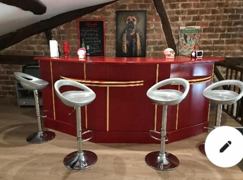 a bar with four stools in front of a counter at Chez Franck et Sandra in Sainte-Menehould