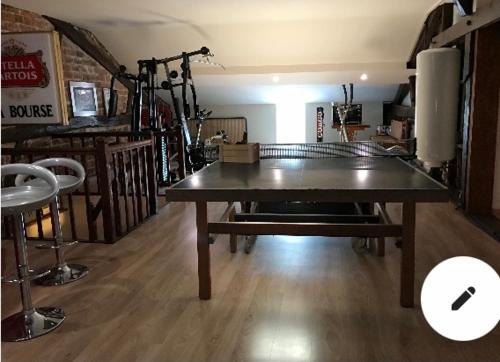 a ping pong table in the middle of a room at Chez Franck et Sandra in Sainte-Menehould