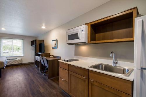 a kitchen with a sink and a microwave at WoodSpring Suites Panama City Beach in Panama City Beach