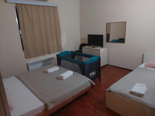 mały pokój z 2 łóżkami i lustrem w obiekcie Shale apartments and rooms w mieście Gewgelija