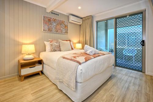 a bedroom with a large bed and a window at Stylish 2 b/r apartment - 4 guests, garage ZC5 in Alexandra Headland