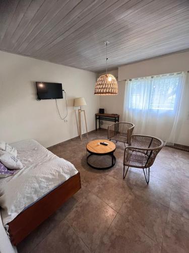 1 dormitorio con cama, mesa y TV en Bella vista en Saldungaray