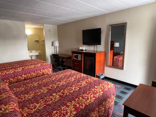 a hotel room with two beds and a flat screen tv at Royal Inn Motel-Charlottesville in Charlottesville