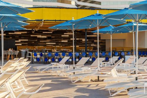 a group of chairs with blue umbrellas and tables at The STRAT Hotel, Casino & Tower in Las Vegas