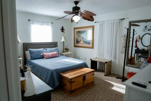 a bedroom with a blue bed and a ceiling fan at La Villetta in Dripping Springs