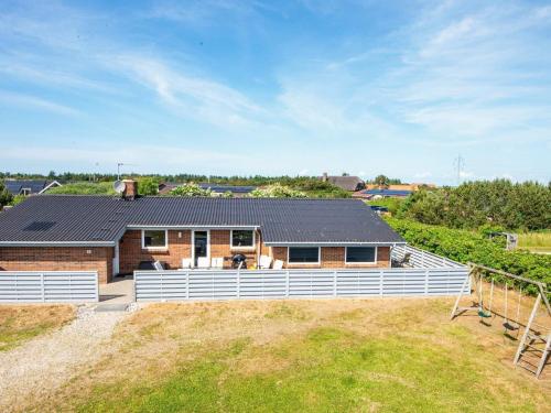 a house with a solar roof on top of a field at 10 person holiday home in Ringk bing in Klegod
