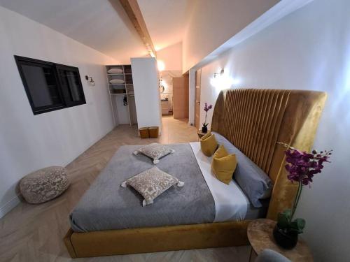 - une chambre avec un grand lit et des oreillers jaunes dans l'établissement VILLA AU COEUR DE L'HERAULT AVEC PISCINE ET SAUNA, à Saint-André-de-Sangonis