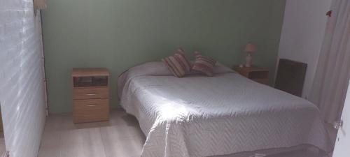 Habitación pequeña con cama y mesita de noche en MAPU PATAGONIA en Puerto Madryn