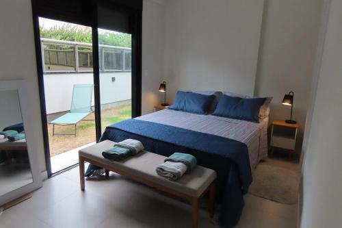 a bedroom with a bed with blue pillows on it at Apartamento Garden em condomínio clube in Florianópolis