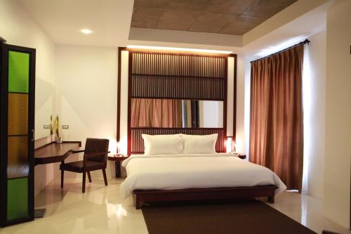 a bedroom with a bed and a desk and a window at S Park Design Hotel in Vientiane
