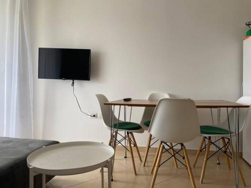 Pokój ze stołem i krzesłami oraz telewizorem w obiekcie The Flip-Flop Apartment w mieście Shëngjin