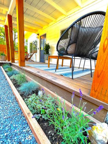 a porch with a bench and flowers on it at Private Wine Country-River Bungalow! Sunny Treetop Views - Pets Stay Free in Forestville