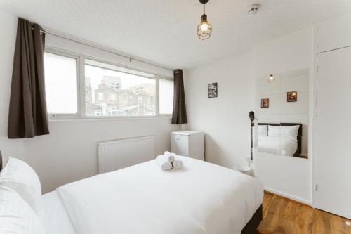 a white bedroom with a white bed and a window at CanningTown Double Rooms - 20 in London