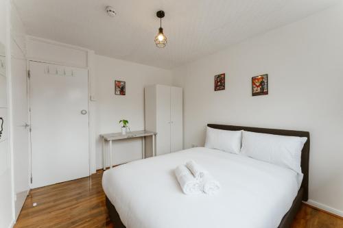 a white bedroom with a large white bed with white pillows at CanningTown Double Rooms - 20 in London