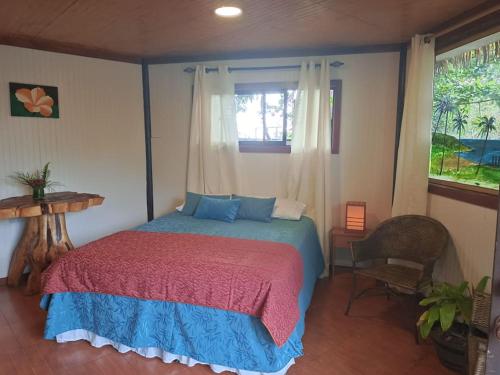a bedroom with a bed and a window at Cabañas Hua'ai Village in Hanga Roa