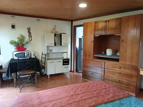 a room with a bed and a desk with a microwave at Cabañas Hua'ai Village in Hanga Roa