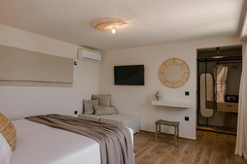 a bedroom with a bed and a couch and a tv at Villa Sensi in Lixouri