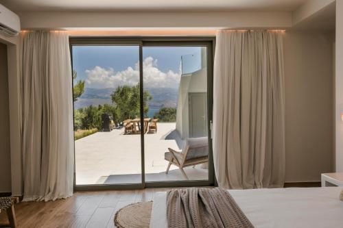 a bedroom with a sliding glass door to a patio at Villa Sensi in Lixouri