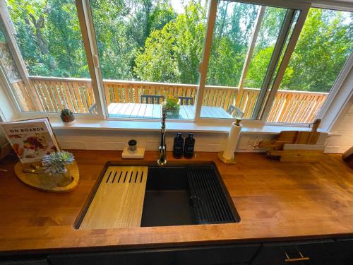 a kitchen with a sink in front of a large window at Private Wine Country-River Bungalow! Sunny Treetop Views - Pets Stay Free in Forestville