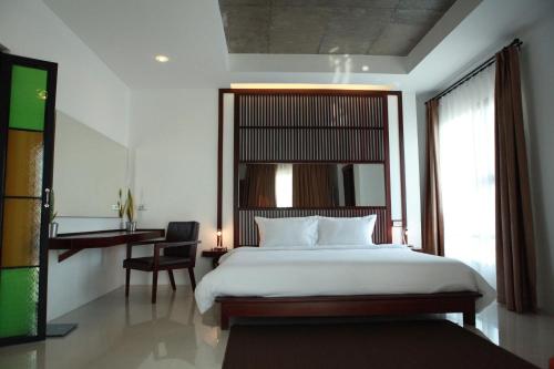 a bedroom with a bed and a chair and a window at S Park Design Hotel in Vientiane
