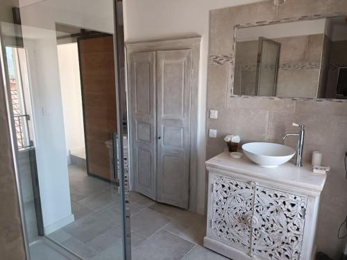 y baño con lavabo y ducha con espejo. en Maison de charme proche Bastia, en Prunelli-di-Casacconi