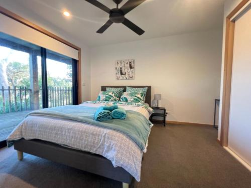 um quarto com uma cama e uma ventoinha de tecto em Coastal Beauty on Bruce em Inverloch
