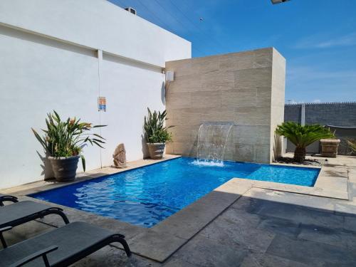 een zwembad met een waterval in een huis bij Bluu Hotel Aeropuerto Monclova-Frontera in Monclova