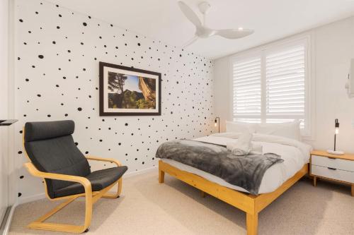 a bedroom with a bed and a chair at Coogee Beach Cosy Home in Sydney