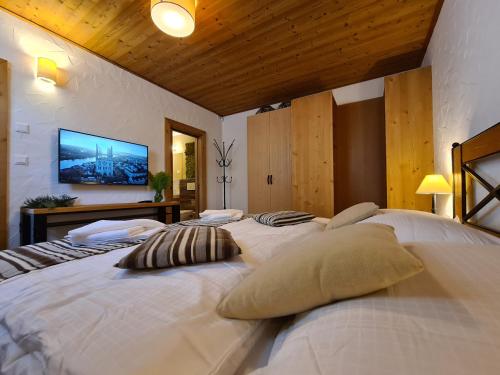 uma grande cama branca com duas almofadas em CHALET ASKALA JASNÁ em Demanovska Dolina
