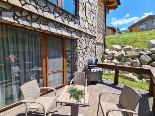 a patio with chairs and a grill on a deck at CHALET ASKALA JASNÁ in Demanovska Dolina